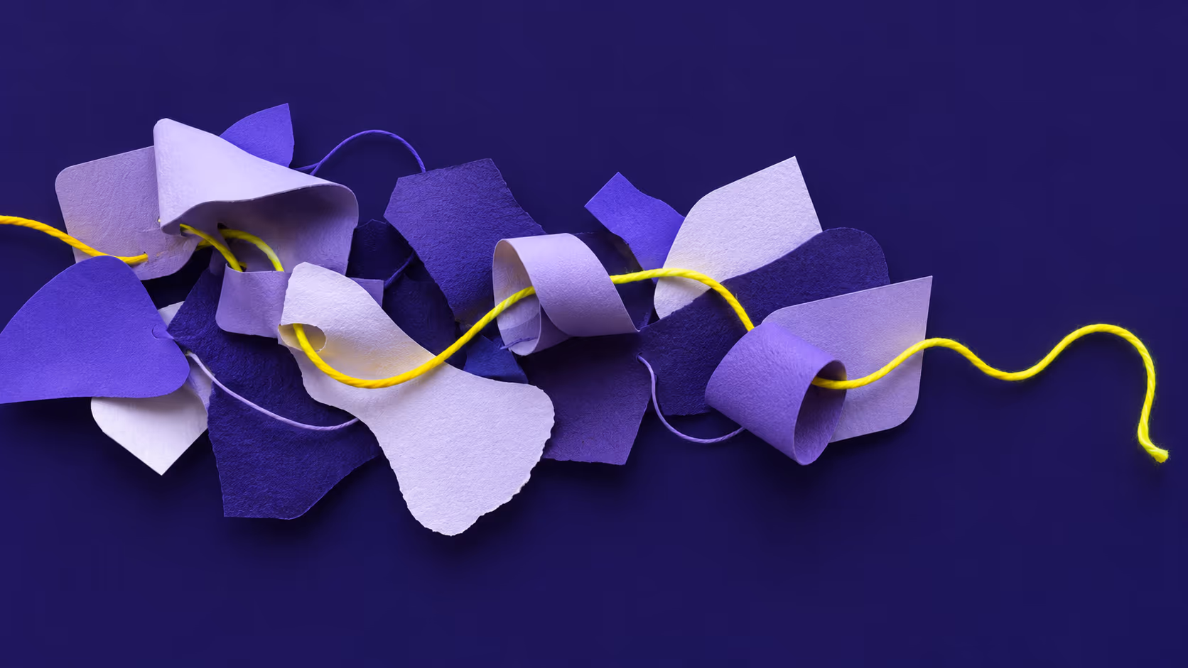 Scraps of purple paper threaded together by a yellow string